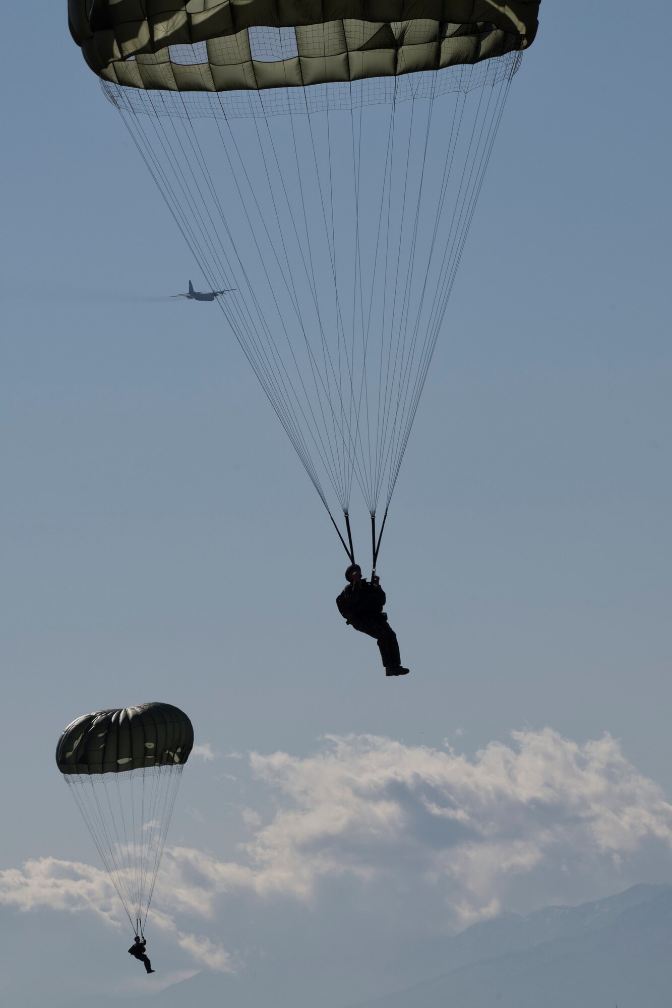 U.S. Marines from the 3rd Reconnaissance Battalion, 3rd Marine Division, III Marine Expeditionary Force drop from a U.S. Air Force C-130 Hercules, assigned to the 36th Airlift Squadron at Yokota Air Base, Japan, Jan. 10, 2017. The training not only allowed the Marines to practice jumping, but it also allowed the Yokota aircrews to practice flight tactics and timed-package drops. (U.S. Air Force photo by Yasuo Osakabe/Released) 