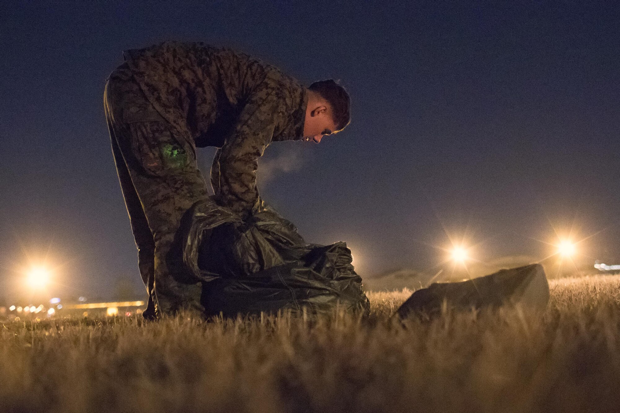 A U.S. Marines form the 3rd Reconnaissance Battalion, 3rd Marine Division, III Marine Expeditionary Force pack a parachute after landing at Yokota Air Base, Japan, Jan. 11, 2017, during Jump Week. The training not only allowed the Marines to practice jumping, but it also allowed the Yokota aircrews to practice flight tactics and timed-package drops. (U.S. Air Force photo by Yasuo Osakabe/Released)  