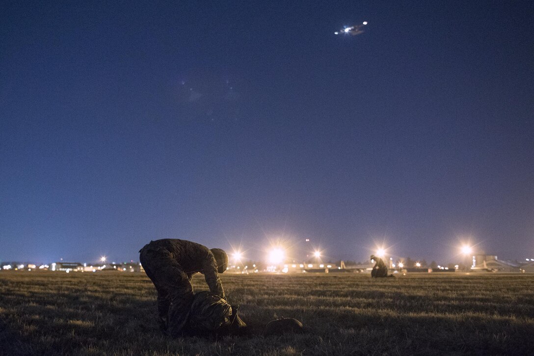 U.S. Marines form the 3rd Reconnaissance Battalion, 3rd Marine Division, III Marine Expeditionary Force packs a parachute after landing at Yokota Air Base, Japan, Jan. 11, 2017, during Jump Week. The training not only allowed the Marines to practice jumping, but it also allowed the Yokota aircrews to practice flight tactics and timed-package drops. (U.S. Air Force photo by Yasuo Osakabe/Released)  
