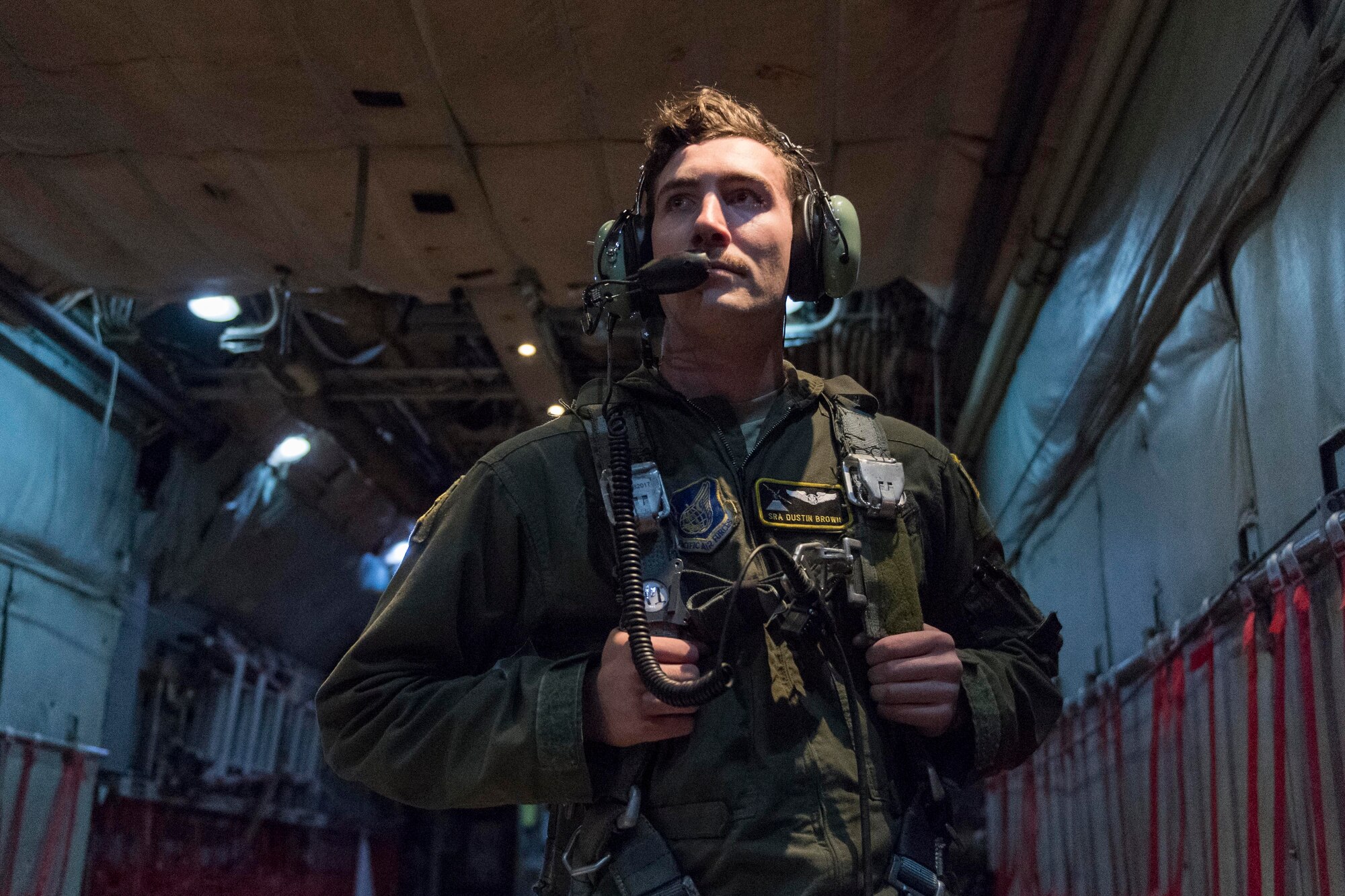 U.S. Air Force Senior Airman Dustin Brown, 36th Airlift Squadron loadmaster, dons a safety harness during jump week at Yokota Air Base, Japan, Jan. 11, 2017. The 36th Airlift Squadron provided airlift support to the U.S. Marine 3rd Reconnaissance Battalion, 3rd Marine Division, III Marine Expeditionary Force’s week-long jump training. (U.S. Air Force photo by Staff Sgt. Michael Washburn/Released)