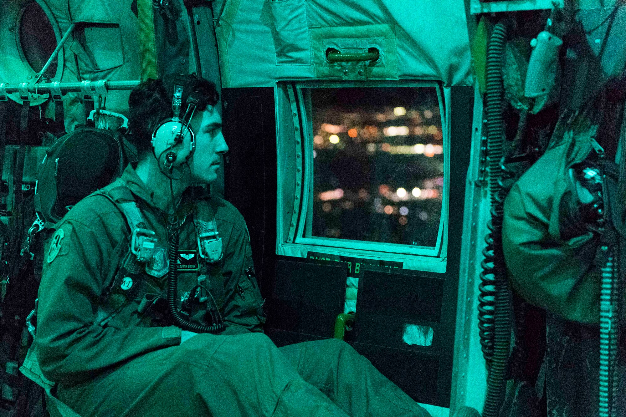 U.S. Air Force Senior Airman Dustin Brown, 36th Airlift Squadron loadmaster, looks out the side door of a C-130 Hercules during jump week at Yokota Air Base, Japan, Jan. 11, 2017. The 36th Airlift Squadron provided airlift support to the U.S. Marine 3rd Reconnaissance Battalion, 3rd Marine Division, III Marine Expeditionary Force’s weeklong jump training. (U.S. Air Force photo by Staff Sgt. Michael Washburn/Released)
