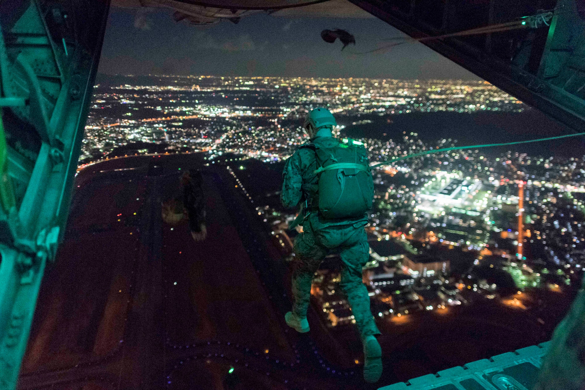 A U.S. Marine from the 3rd Reconnaissance Battalion, 3rd Marine Division, III Marine Expeditionary Force jumps from the back of a U.S. Air Force C-130 Hercules during jump week at Yokota Air Base, Japan, Jan. 11, 2017. The training not only allowed the Marines to practice jumping, but it also allowed the Yokota aircrews to practice flight tactics and timed-package drops. (U.S. Air Force photo by Staff Sgt. Michael Washburn/Released)