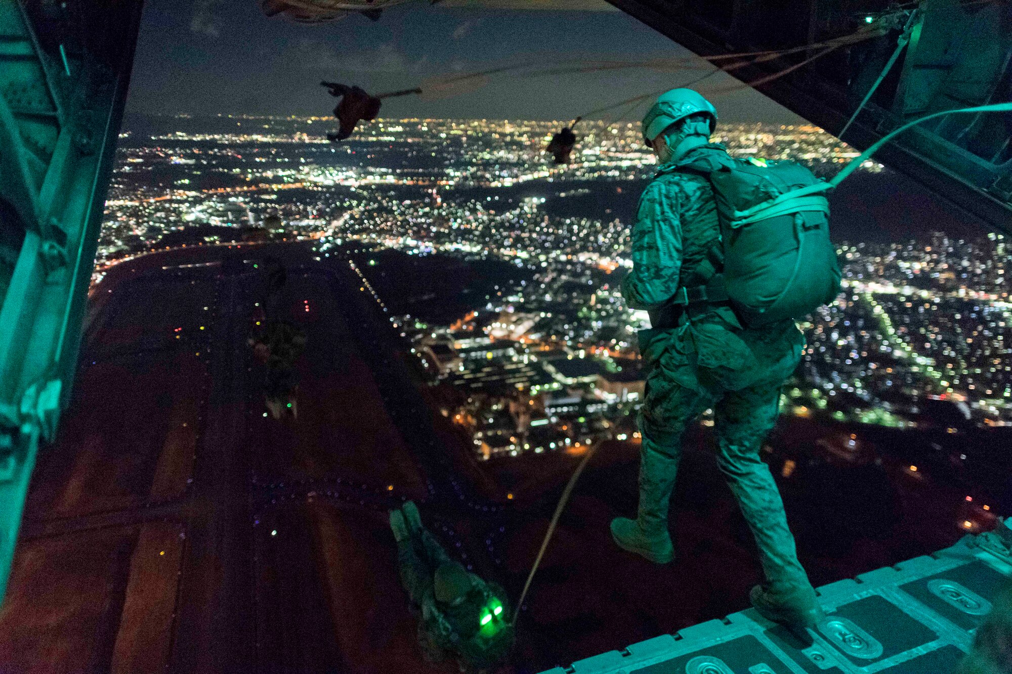 U.S. Marines from the 3rd Reconnaissance Battalion, 3rd Marine Division, III Marine Expeditionary Force jump from the back of a U.S. Air Force C-130 Hercules during jump week at Yokota Air Base, Japan, Jan. 11, 2017. The training not only allowed the Marines to practice jumping, but it also allowed the Yokota aircrews to practice flight tactics and timed-package drops. (U.S. Air Force photo by Staff Sgt. Michael Washburn/Released)