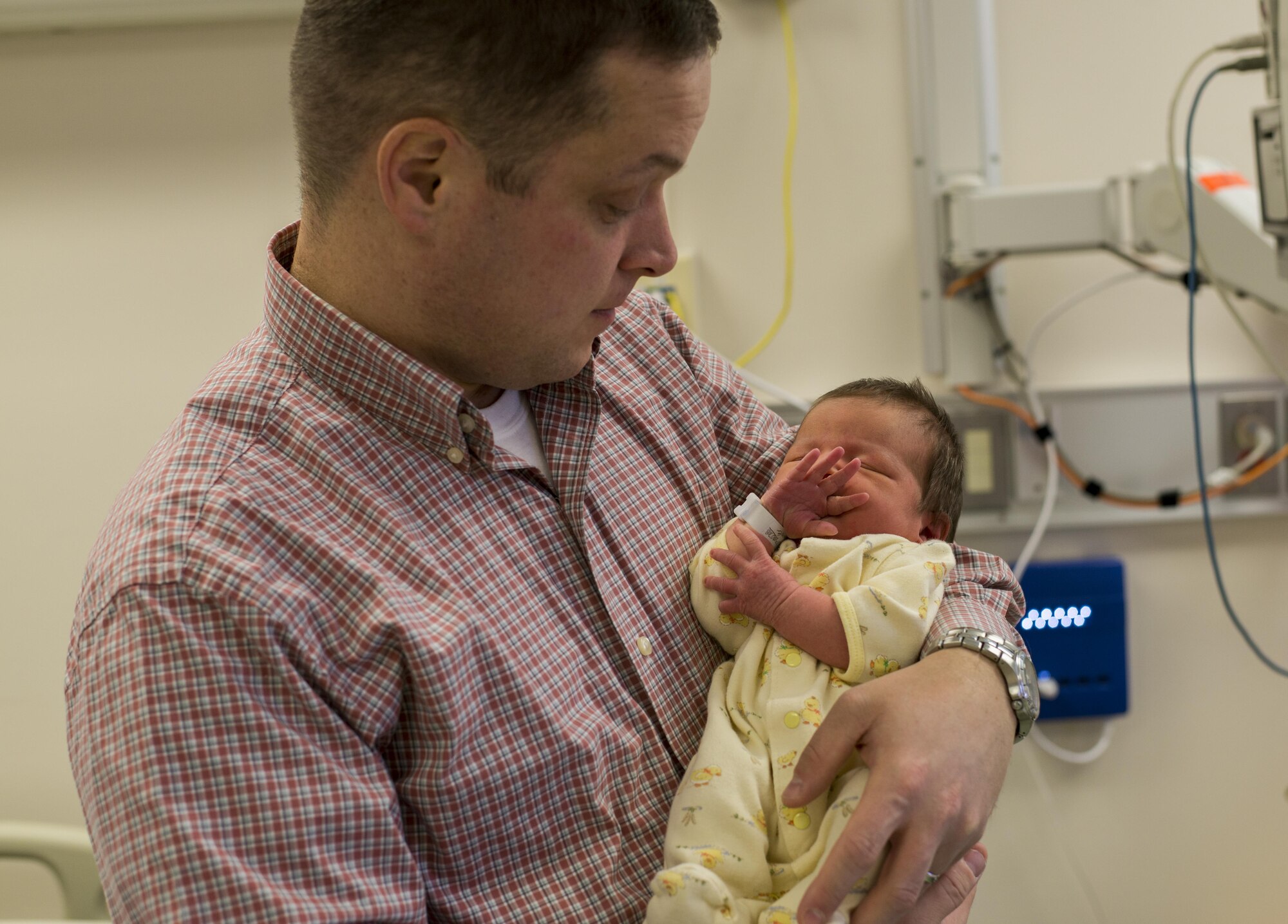U.S. Coast Guard Lt. Cmdr. Kevin A. Beaudoin, U.S. Coast Guard Activities Far East Division International Port Security liaison officer, holds his newborn daughter, Beatrice M. Beaudoin, first baby born in the New Year at Yokota, in his arms Jan 8, 2017, at Yokota Air Base, Japan. Beatrice was one of four babies born on this date in Yokota. (U.S. Air Force photo by Airman 1st Class Juan Torres)