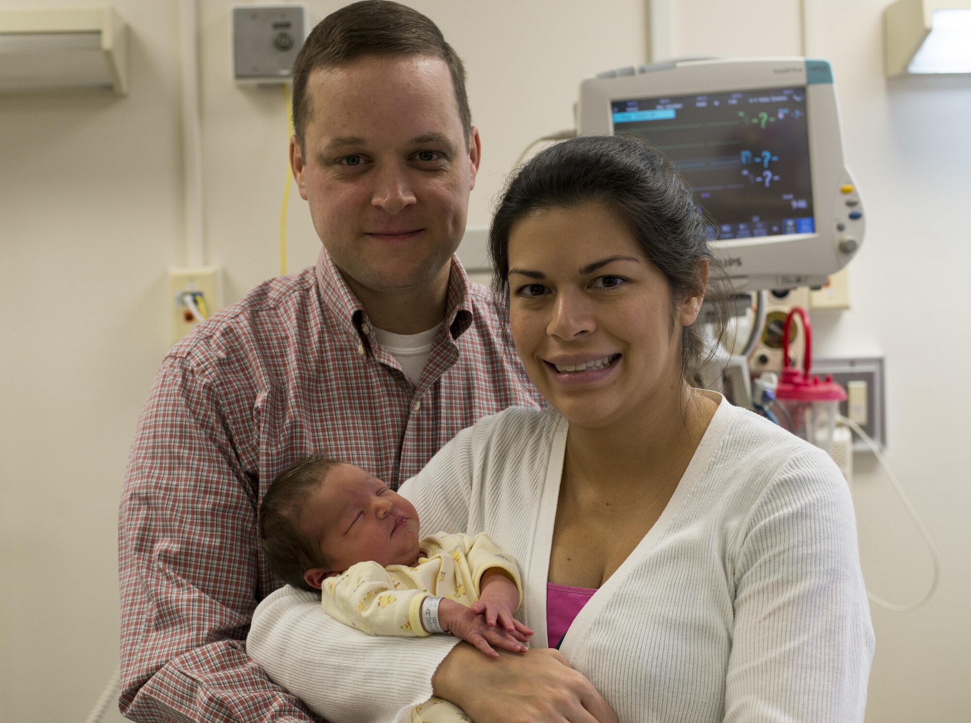 U.S. Coast Guard Lt. Cmdr. Kevin A. Beaudoin, U.S. Coast Guard Activities Far East Division International Port Security liaison officer, and Jasmine A. Beaudoin, pose for a photo with their newborn daughter, Beatrice M. Beaudoin, first baby born in the New Year at Yokota, Jan. 8, 2017, at Yokota Air Base, Japan. Beatrice was one of four babies born on this date in Yokota. (U.S. Air Force photo by Airman 1st Class Juan Torres)