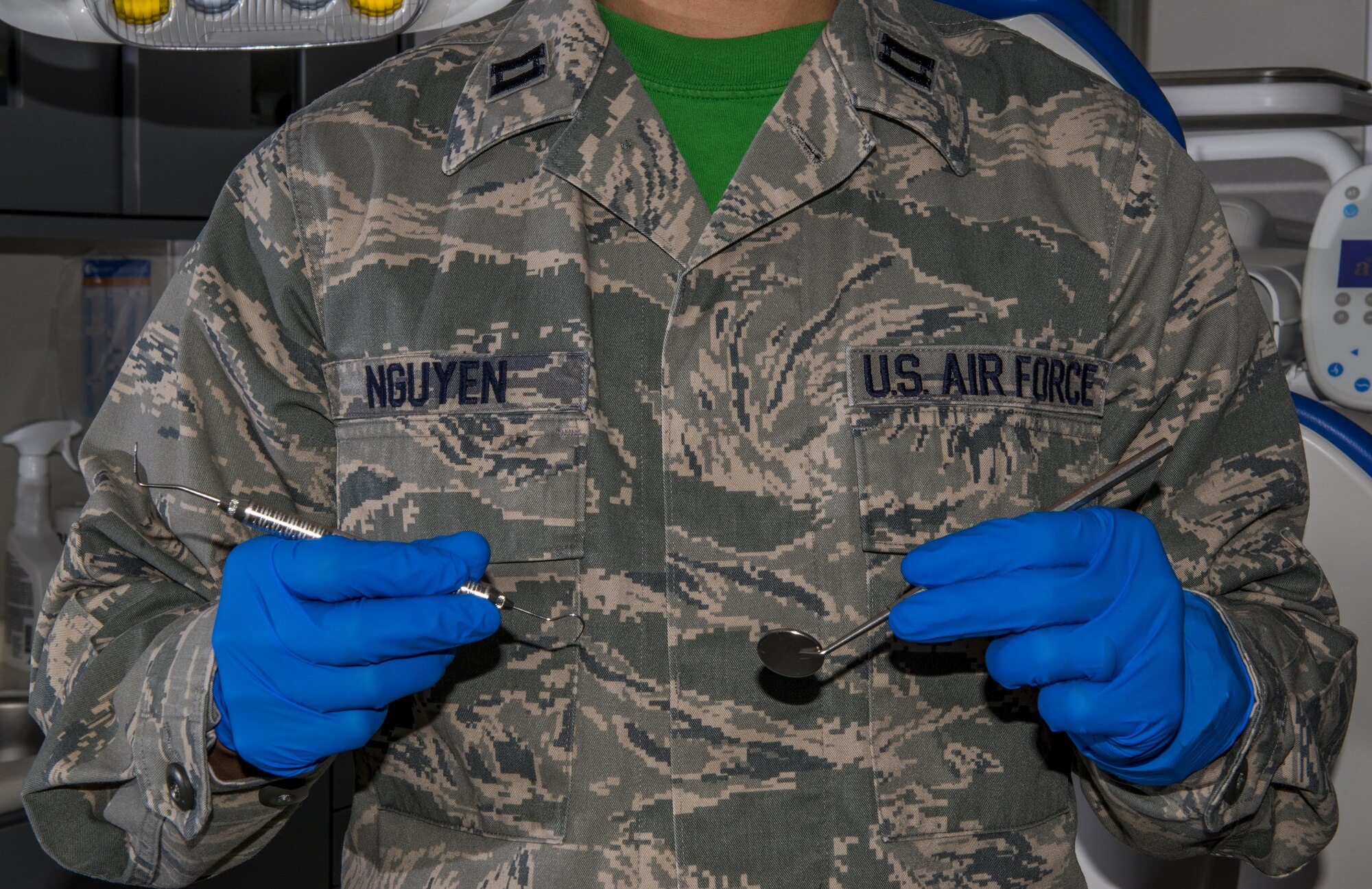 Capt. Duy Q. Nguyen, 374th Dental Squadron general dentist, poses for a photo while holding dental instruments Dec. 23, 2016, at Yokota Air Base, Japan. The 374 DS plays a role in Pacific Command's Global Health Engagement by participating in Pacific Angel humanitarian missions. (U.S. Air Force photo by Airman 1st Class Juan Torres)