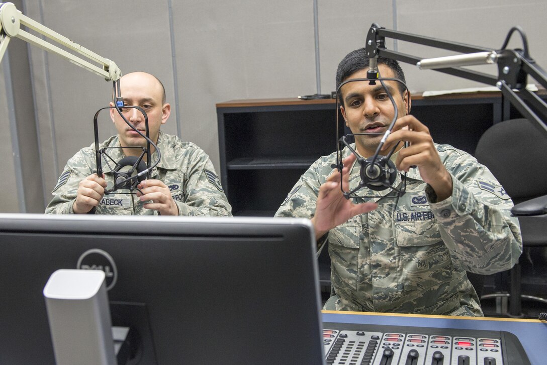 Airman 1st Class Dhruv Gopinath (right), American Forces Network Tokyo broadcaster, and Staff Sgt. John Drabeck, AFN Tokyo maintenance technician, prepare for a radio show at Yokota Air Base, Japan, Jan. 9, 2017. As an AFN broadcaster, Gopinath's duties include video documentation, command information and radio production. (U.S. Air Force photo by Senior Airman David C. Danford)