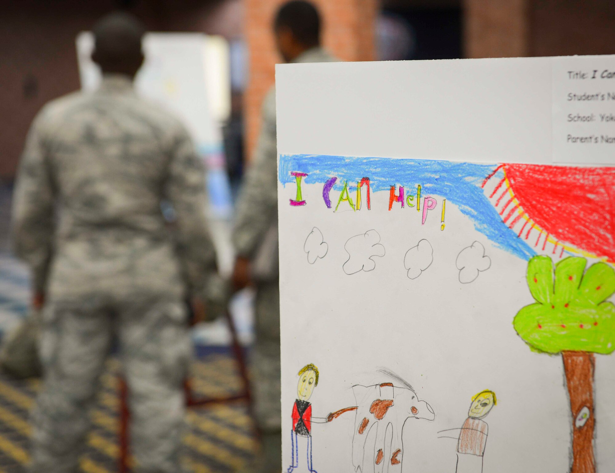A Yokota West Elementary School child’s artwork stands on display for “The Story of a Dream,” art gallery and play honoring Martin Luther King Jr. and African American suffrage of the mid 1950s at Yokota Air Base, Jan. 12, 2017. The artwork shared the theme of “I can help,” and displayed children’s ideas of how to build a positive environment. (U.S. Air Force photo by Senior Airman Elizabeth Baker)