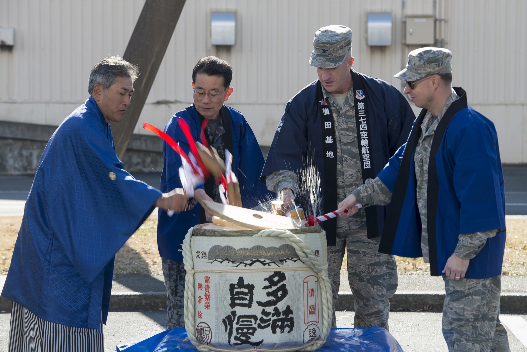Col. Kenneth Moss, 374th Airlift Wing commander, Col. John Winkler, 374th Mission Support Group commander, break open a barrel on New Year sake alongside Japan Air Self-Defense Force Operation Support Wing leadership at Yokota Air Base, Japan, Jan. 13, 2017. The event included traditional festival food, a performance from the Samurai Taiko Drum Team, musicians playing the koto and shamisen and tea ceremonies. (U.S. Air Force photo by Senior Airman David C. Danford)