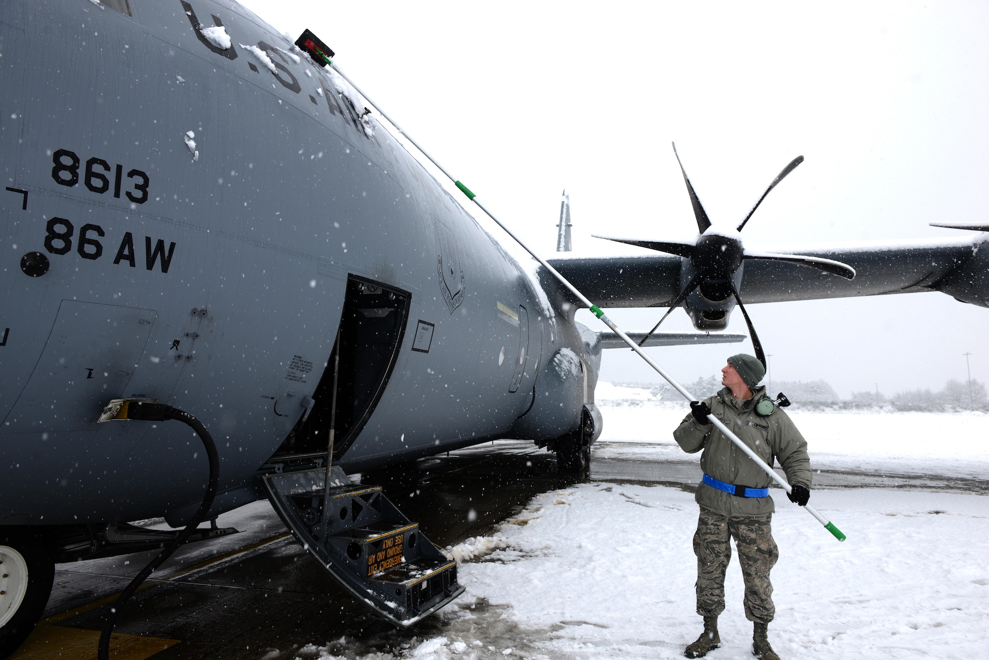 Airman 1st Class Jacob Taatjes, 86th Aircraft Maintenance Squadron crew chief, removes snow from a C-130J Super Hercules aircraft at Ramstein Air Base, Germany, Jan. 10, 2017. Continuous heavy snow persisted throughout the majority of the day, prompting snow removal operations throughout the base.. (U.S. Air Force photo by Airman 1st Class Joshua Magbanua)