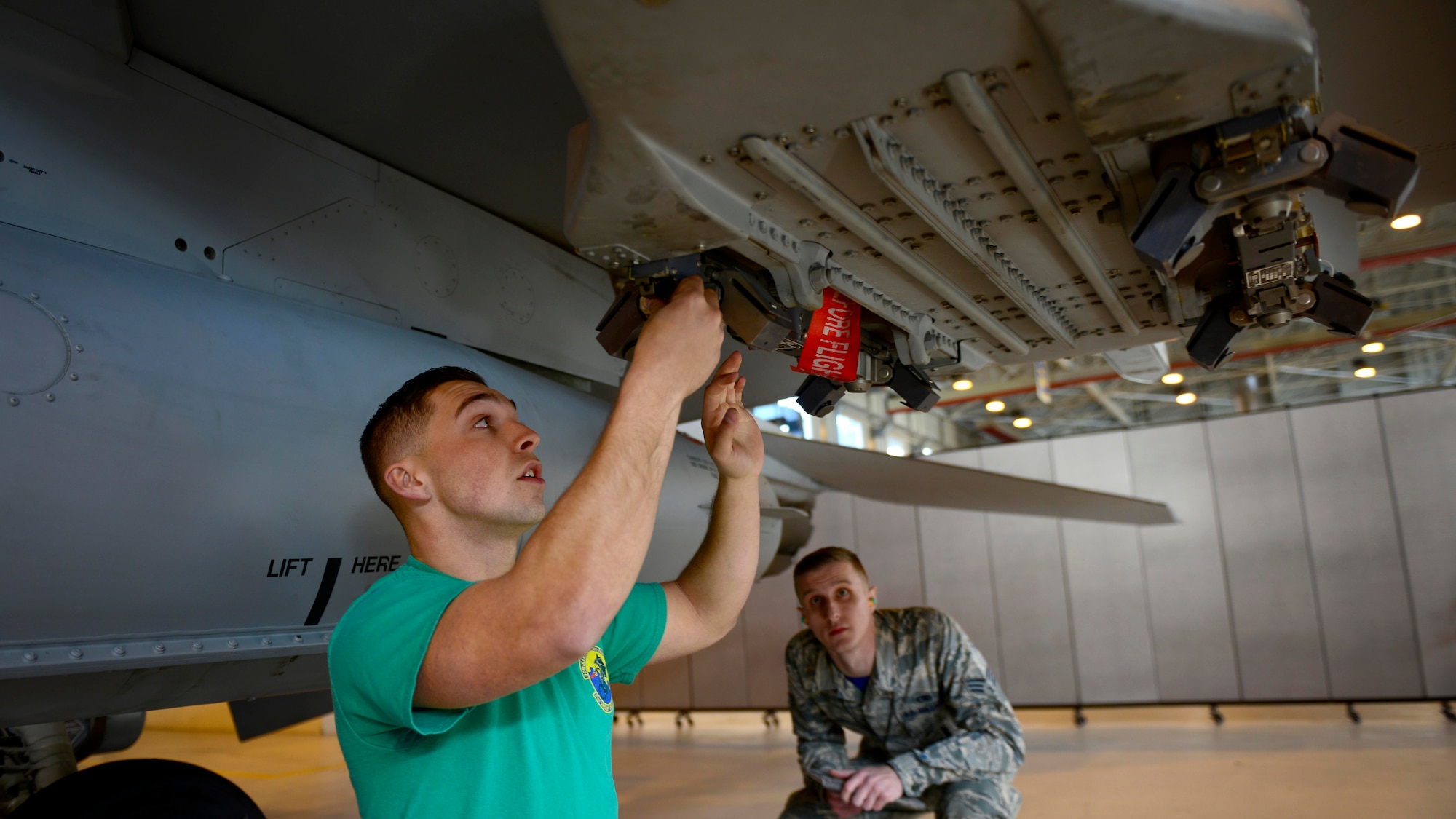 Airman 1st Class Waylon Scheirer, left, 31st Aircraft Maintenance Squadron weapons load crew member, prepares to load munitions on an F-16 Fighting Falcon while Senior Airman Michael Velasco, load competition judge, observes him during the annual load competition at Aviano Air Base, Italy on January 6, 2017. Each year, the squadron’s top weapons load crew teams compete to be awarded the 31st Fighter Wing Best Load Crew of the Year award. (U.S. Air Force photo by Senior Airman Areca T. Bell)