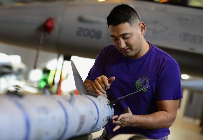 Staff Sgt. Patrick Peralta, 31st Aircraft Maintenance Squadron weapons load crew member, prepares to load an inert munition onto an F-16 Fighting Falcon during the annual load crew competition at Aviano Air Base, Italy on Jan. 6, 2016. Three 3-person teams competed for the 31st Fighter Wing’s Best Load Crew of the Year award. (U.S. Air Force photo by Staff Sgt. Krystal Ardrey)