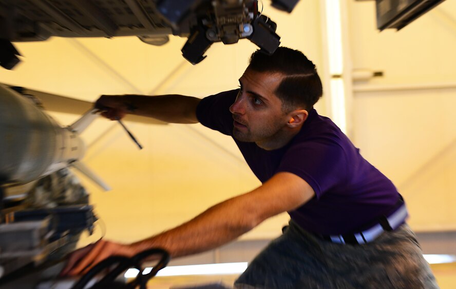 Staff Sgt. John Weiler, 31st Aircraft Maintenance Squadron weapons load crew chief, loads an inert munition onto an F-16 Fighting Falcon during a load crew competition at Aviano Air Base, Italy on Jan. 6, 2016. The three 3-person teams were judged on their job knowledge, dress and appearance, and munitions load performance. (U.S. Air Force photo by Staff Sgt. Krystal Ardrey)