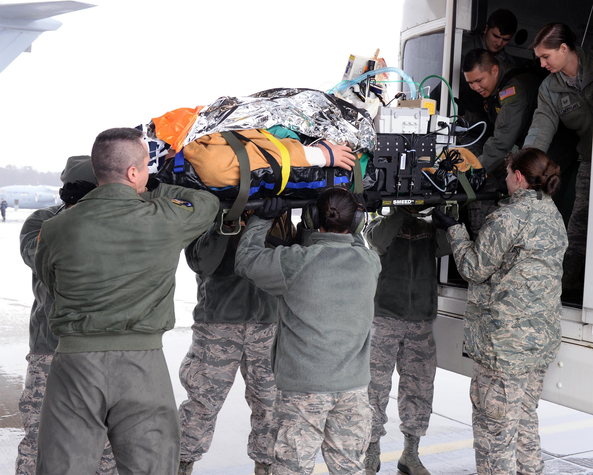 Airmen receive a simulated critical care patient from a transport vehicle during an exercise at Ramstein Air Base, Germany, Jan. 11, 2017. Patients who are in critical status are accompanied by critical care air transportation teams who ride and fly with them until they reach their destination. (U.S. Air Force photo by Senior Airman Jimmie D. Pike)