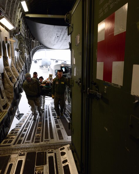 Medics carry a simulated patient onto a C-17 Globemaster II during a training exercise on Ramstein Air Base, Germany, Jan. 11, 2017. Airmen trained in specific duties of their job during an exercise that incorporated aeromedical personnel, critical care air transport teams, and en route patient staging systems. (U.S. Air Force photo by Senior Airman Jimmie D. Pike)