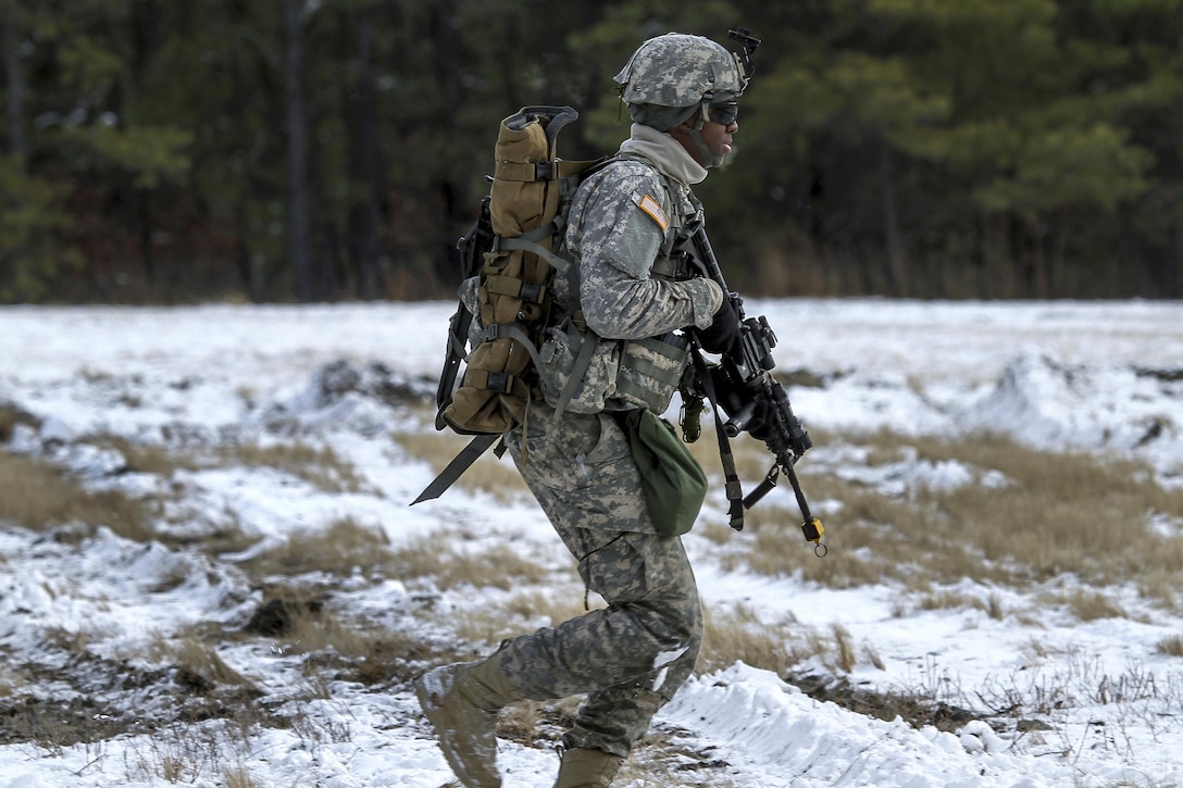 A New Jersey Army National Guardsmen runs toward the wood line after an air insertion by Marine Corps Reserve UH-1Y Huey helicopters during a joint-training exercise at Joint Base McGuire-Dix-Lakehurst, N.J., Jan. 10, 2017. Air National Guard photo by Tech. Sgt. Matt Hecht