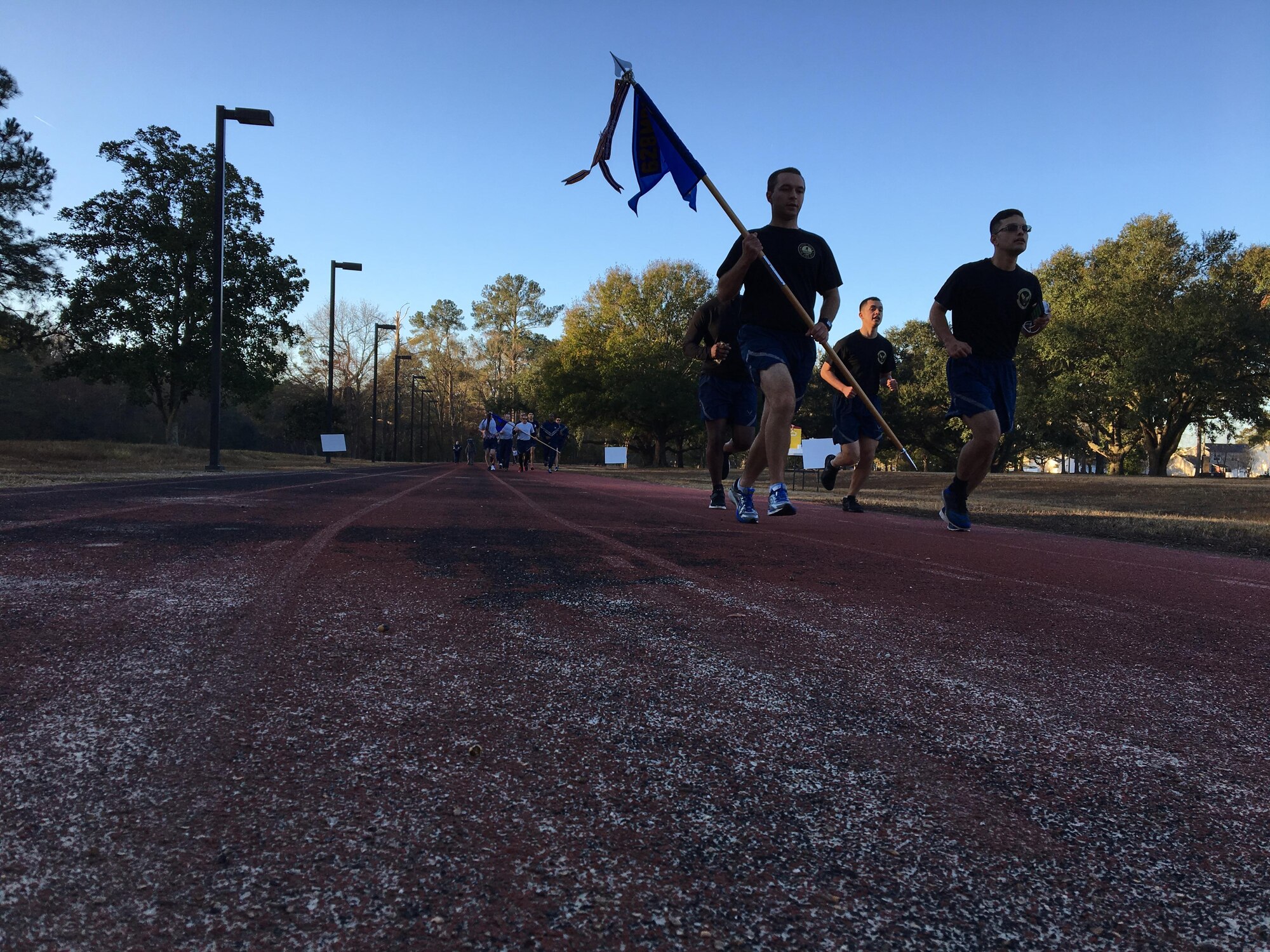 2nd Lt. Brett Betit, 628th Civil Engineer Squadron (CES) programmer, runs with the 628th CES guidon during the Wingman Day Olympics here, Jan. 13. For Wingman Day Airmen participated in various events with their squadrons to foster teamwork and communication while covering the four domains of Comprehensive Airmen Fitness.
