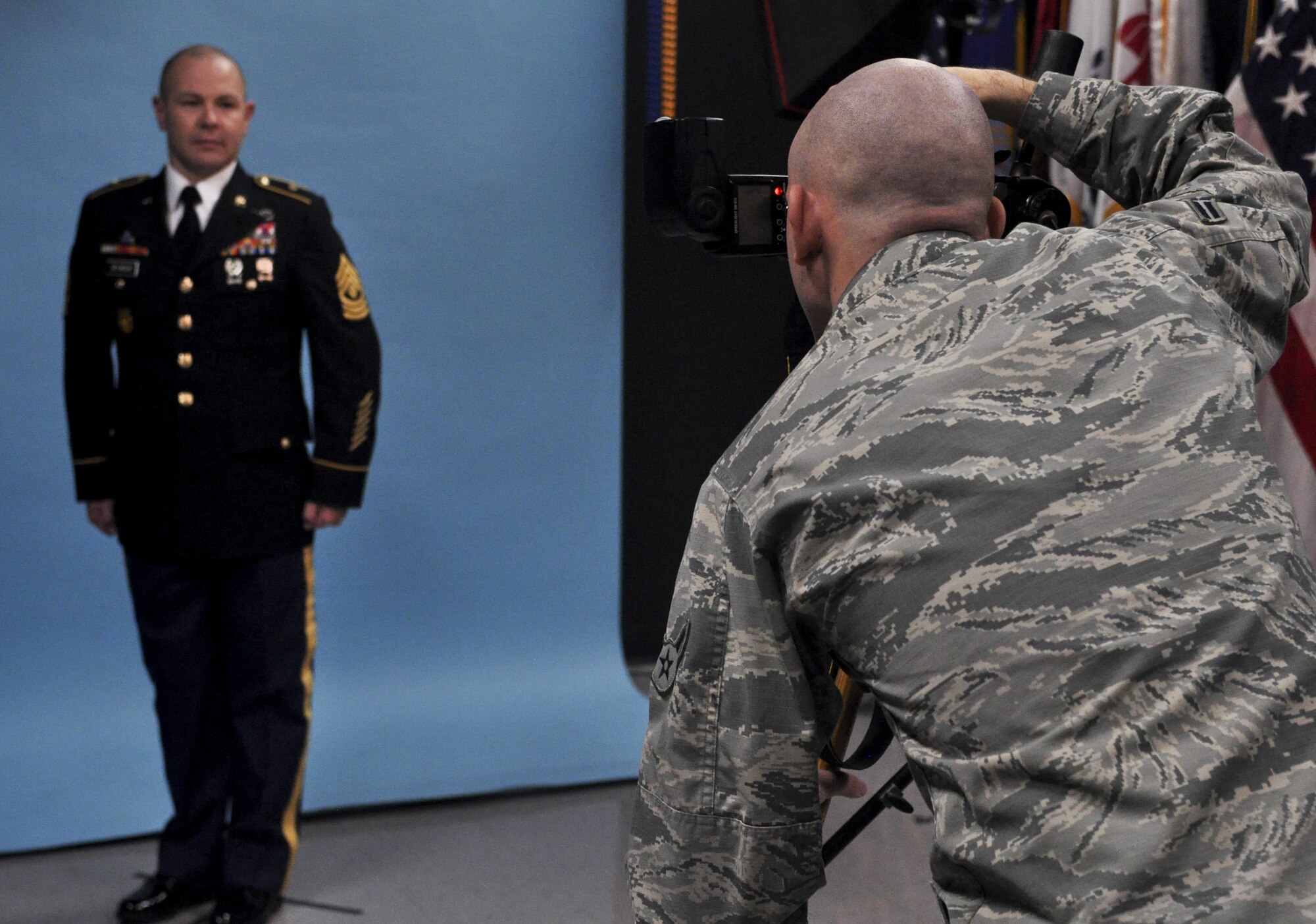 U.S. Air Force Airman 1st Class Randall Moose, 17th Training Wing Public Affairs photojournalist, takes an official photo of U.S. Army Master Sgt. Christopher Seymour, 344th military intelligence battalion, in the public affairs building on Goodfellow Air Force Base, Texas, January 12, 2016. The Public Affairs office takes official photos for all services on Goodfellow. (U.S. Air Force photo by 2nd Lt. Tisha Wilkerson/Released)