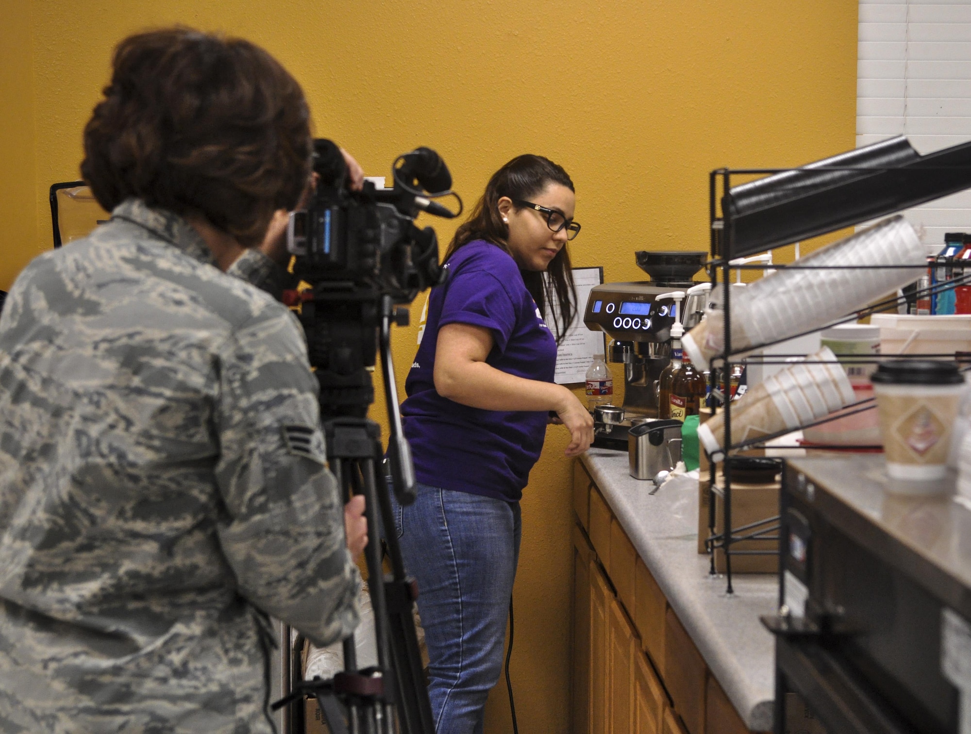 U.S. Air Force Senior Airman Megan Reed, 17th Training Wing Public Affairs broadcast journalist, gathers b-roll of the grand opening of a coffee shop on Goodfellow Air Force Base, Texas, January 13, 2016. The public affairs office covers events happening on or off base that impact Goodfellow. (U.S. Air Force photo by 2nd Lt. Tisha Wilkerson/Released)