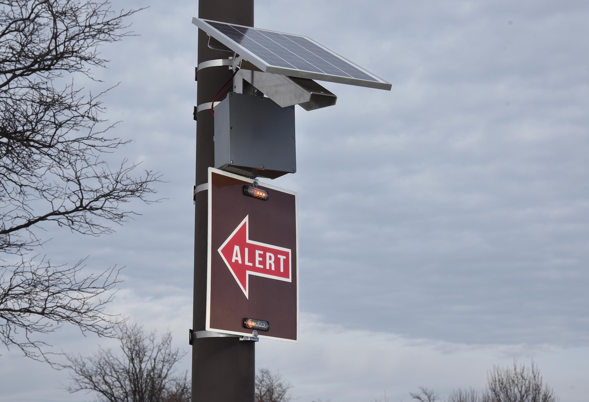 Tech. Sgt. Clayton Allen, 22nd Air Refueling Wing Plans and Programs NCO in-charge, installs an alert route sign on a base light pole, Nov. 17, 2016, at McConnell Air Force Base, Kan. Allen and Master Sgt. Bartek Bachleda, 22nd ARW XP superintendent, designed and built the signs, potentially saving the Air Force millions of dollars. (Courtesy photo/Master Sgt. Bartek Bachleda)