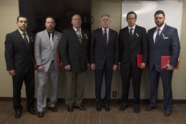 The Secretary of the Navy Ray Mabus, middle right, poses for a photo with four Marines and one Sailor following an awards ceremony at Marine Corps Air Station Cherry Point, N.C., Jan. 13, 2017. The four Marines and one Sailor included, from left to right, Staff Sgt. Michael Mendoza, who received a Navy Cross; and Master Sgt. Steven Davis; HM1 Michael Atkinson; Sgt. Nicholas Brandau; and Sgt. Edward Huth, who were each awarded a Silver Star for their actions. 