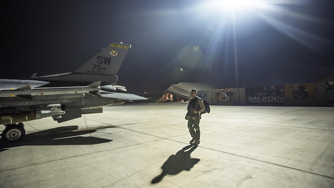 Capt. David, 79th Expeditionary Fighter Squadron pilot, walks out to an F-16 Fighting Falcon before a night mission Jan. 13, 2017 at Bagram Airfield, Afghanistan. David enlisted in the Air Force in 2004 as an F-16 avionics specialist and now flies the same airframe he used to maintain. (U.S. Air Force photo by Staff Sgt. Katherine Spessa)