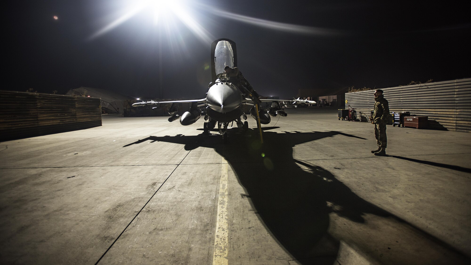Capt. David, 79th Expeditionary Fighter Squadron pilot, and Staff Sgt. Daniel Lasal, 455th Expeditionary Aircraft Maintenance Squadron dedicated crew chief, prepare an F-16 Fighting Falcon for a night mission Jan. 13, 2017 at Bagram Airfield, Afghanistan. David served as an aircraft maintainer for eight years before commissioning as a pilot in 2012. (U.S. Air Force photo by Staff Sgt. Katherine Spessa)