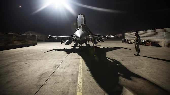 Capt. David, 79th Expeditionary Fighter Squadron pilot, and Staff Sgt. Daniel Lasal, 455th Expeditionary Aircraft Maintenance Squadron dedicated crew chief, prepare an F-16 Fighting Falcon for a night mission Jan. 13, 2017 at Bagram Airfield, Afghanistan. David served as an aircraft maintainer for eight years before commissioning as a pilot in 2012. (U.S. Air Force photo by Staff Sgt. Katherine Spessa)
