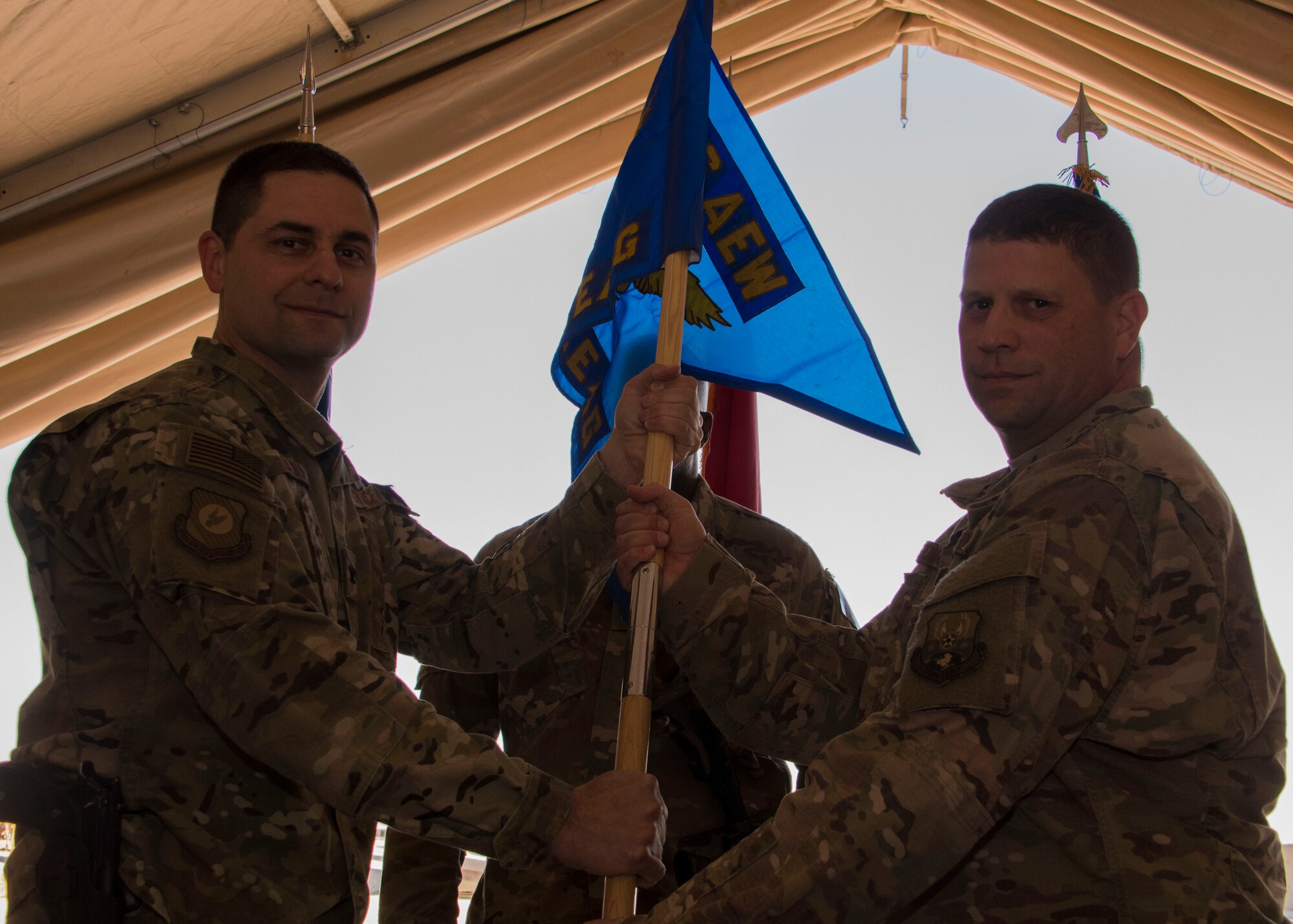 U.S. Air Force Col. Jay Sabia, 370th Air Expeditionary Advisory Group commander, left, gives the group flag to U.S. Air Force Lt. Col. Jim Eddleman, the incoming 370th AEAG Detachment 1 commander, right, at a change of command ceremony, Jan. 8, 2017 at Al Asad Air Base, Iraq. Possession of the flag symbolizes command over the unit. (U.S. Air Force photo/Senior Airman Andrew Park)