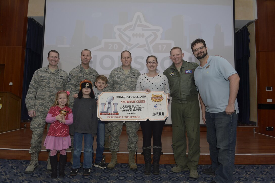 U.S. Air Force Staff Sgt. Richard Crites, 52nd Maintenance Squadron senior munitions inspector, with his family are presented with the grand prize from the Football Frenzy contest by 52nd Fighter Wing leadership and 52nd Force Support Squadron at Club Eifel on Spangdahlem Air Base, Germany, Jan. 10, 2017. The grand prize is two tickets to Super Bowl LI with airfare and hotel. (U.S. Air Force photo
by Staff Sgt. Jonathan Snyder)