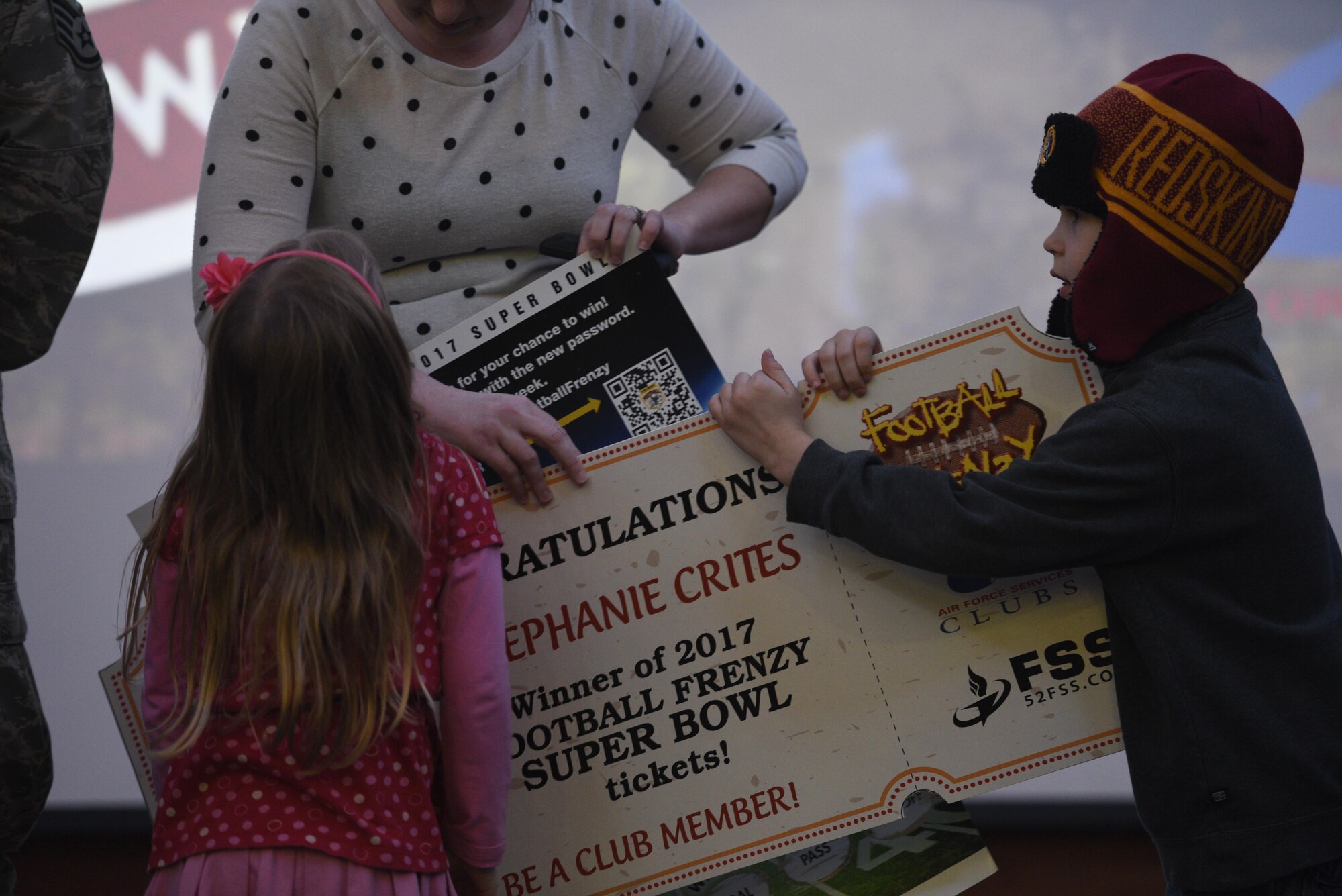 Colton Crites, right, son of U.S. Air Force Staff Sgt. Richard Crites, 52nd Maintenance Squadron senior munitions inspector, holds the giant ticket from the Football Frenzy contest at Club Eifel on Spangdahlem Air Base, Germany, Jan. 10, 2017. The grand prize is two tickets to Super Bowl LI with airfare and hotel. (U.S. Air Force photo by Staff Sgt. Jonathan Snyder)