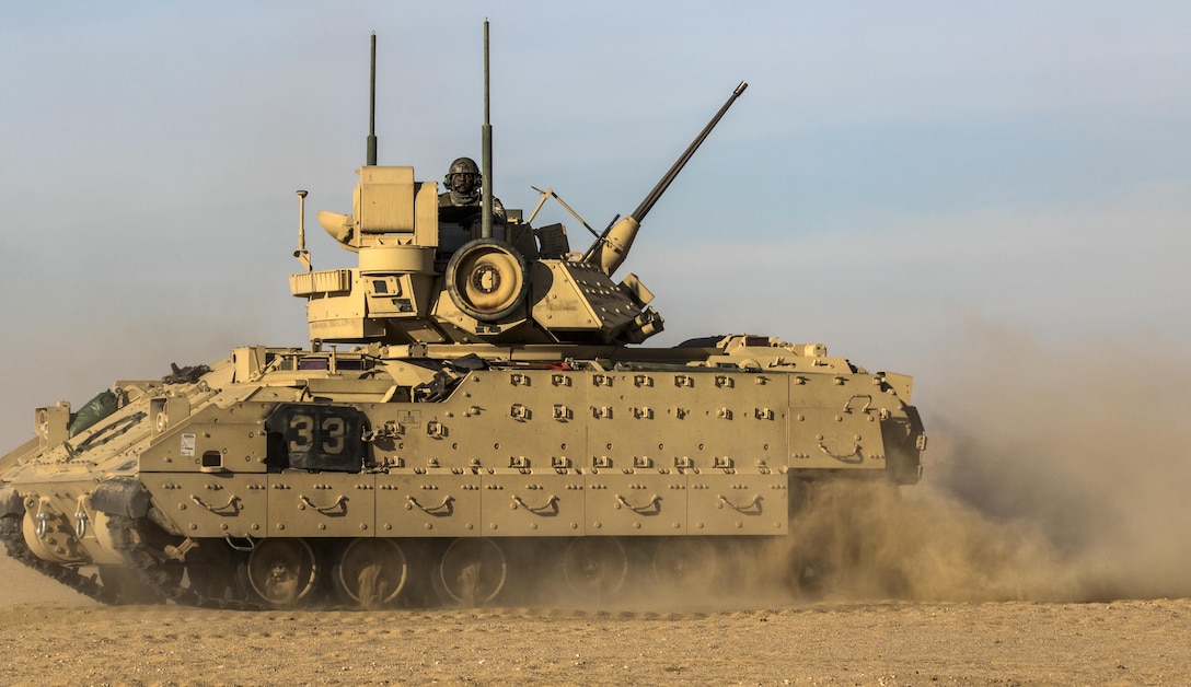 A Soldier in a Bradley Fighting Vehicle from the 1st Battalion, 77th Armored Regiment looks for opposing forces at Udairi Training Range in Kuwait recently as part of a combined exercise. The Cavalry Scouts responded to contact with a notional enemy during the exercise, before providing critical intelligence for Soldiers from the 197th Field Artillery Brigade to provide fire support. (U.S. Army photo by Sgt. Brandon Hubbard, USARCENT Public Affairs)