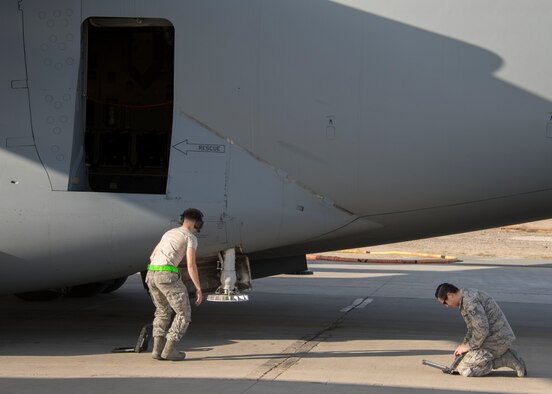 Airman 1st Class Nathan Travis, an aircraft electrical and environment systems journeyman, left, and Staff Sgt. Bradley Chaplin, an aerospace maintenance craftsman, right, both from the 5th Expeditionary Air Mobility Squadron, begin a post-flight inspection of a C-17 Globemaster III at an undisclosed location in Southwest Asia Jan. 13, 2017.  The 5th EAMS consists of 65 maintenance personnel. (U.S. Air Force photo/Senior Airman Andrew Park)