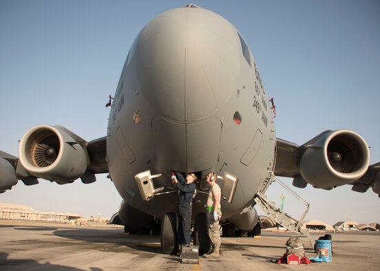 Two Airmen from the 5th Expeditionary Air Mobility Squadron, grease points on the nose landing gear of a C-17 Globemaster III during a post-flight inspection at an undisclosed location in Southwest Asia Jan. 13, 2017. The squadron flies an average of 2,500 sorties a year, moving 180,000 personnel and 80,000 tons of cargo. (U.S. Air Force photo/Senior Airman Andrew Park)