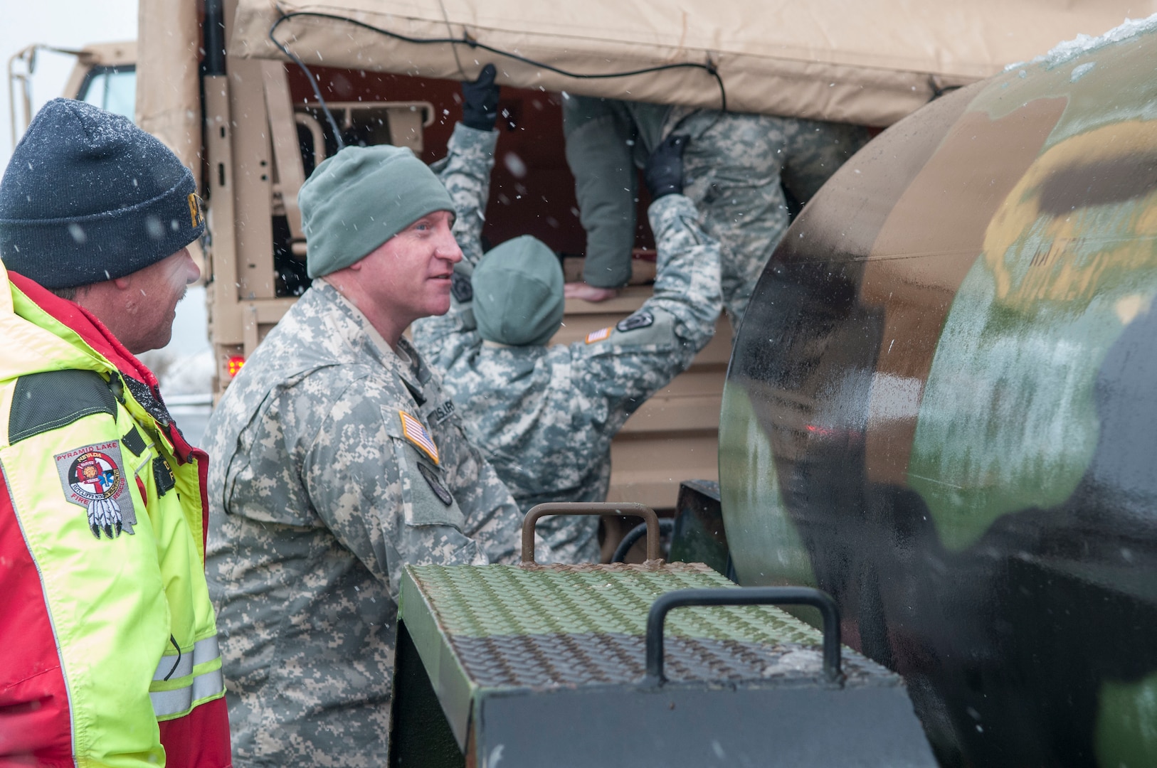 Sgt. 1st Class Justin Juliot, center, of the Nevada National Guard's 422nd Expeditionary Support Battalion, unhitches a 400-gallon water tank, commonly refereed to as a "water buffalo," to provide water for the town of Sutcliffe on Pyramid Lake Tribal land about 40 miles north of Reno, Jan. 12, 2017. The town of Sutcliffe has been without basic water services since water rushed down the western and eastern slopes of the Sierra Nevada mountain range Jan. 8, causing floods around the region and damaging fresh water pipeline to Sutcliffe.