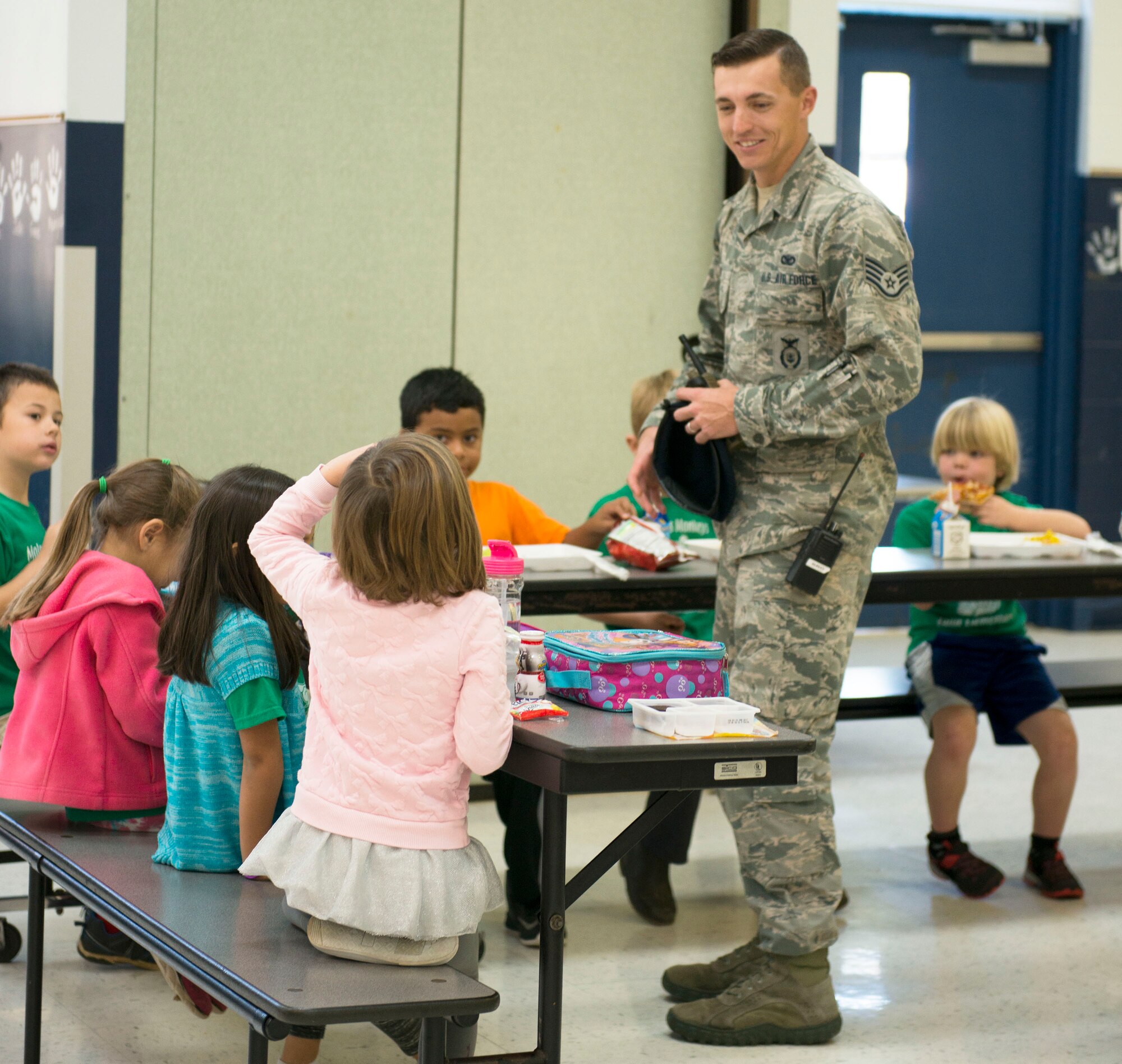 Staff Sgt. Justin Hogg, 96th Security Forces Squadron, visits with students about his new position over their lunch break Jan. 13 at Eglin Air Force Base, Fla.  Hogg is the School Resource Officer for Eglin Elementary School and is in charge of providing security and crime prevention services on the campus. (U.S. Air Force photo/Cheryl Sawyers)