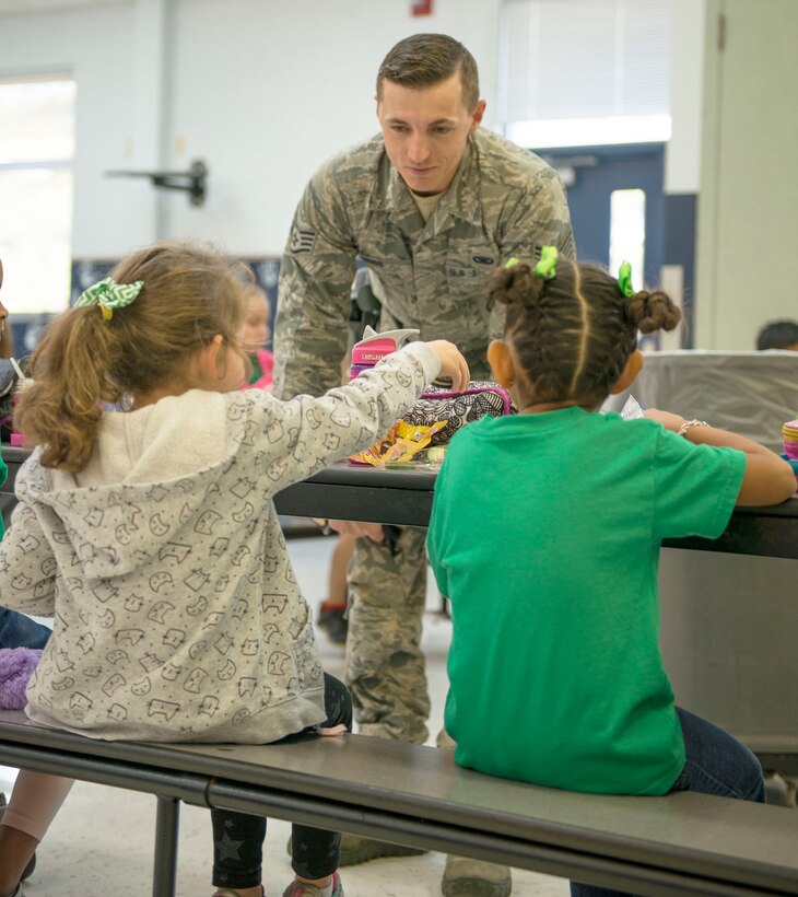 Staff Sgt. Justin Hogg, 96th Security Forces Squadron, visits with students about his new position over their lunch break Jan. 13 at Eglin Air Force Base, Fla.  Hogg is the School Resource Officer for Eglin Elementary School and is in charge of providing security and crime prevention services on the campus. (U.S. Air Force photo/Cheryl Sawyers)