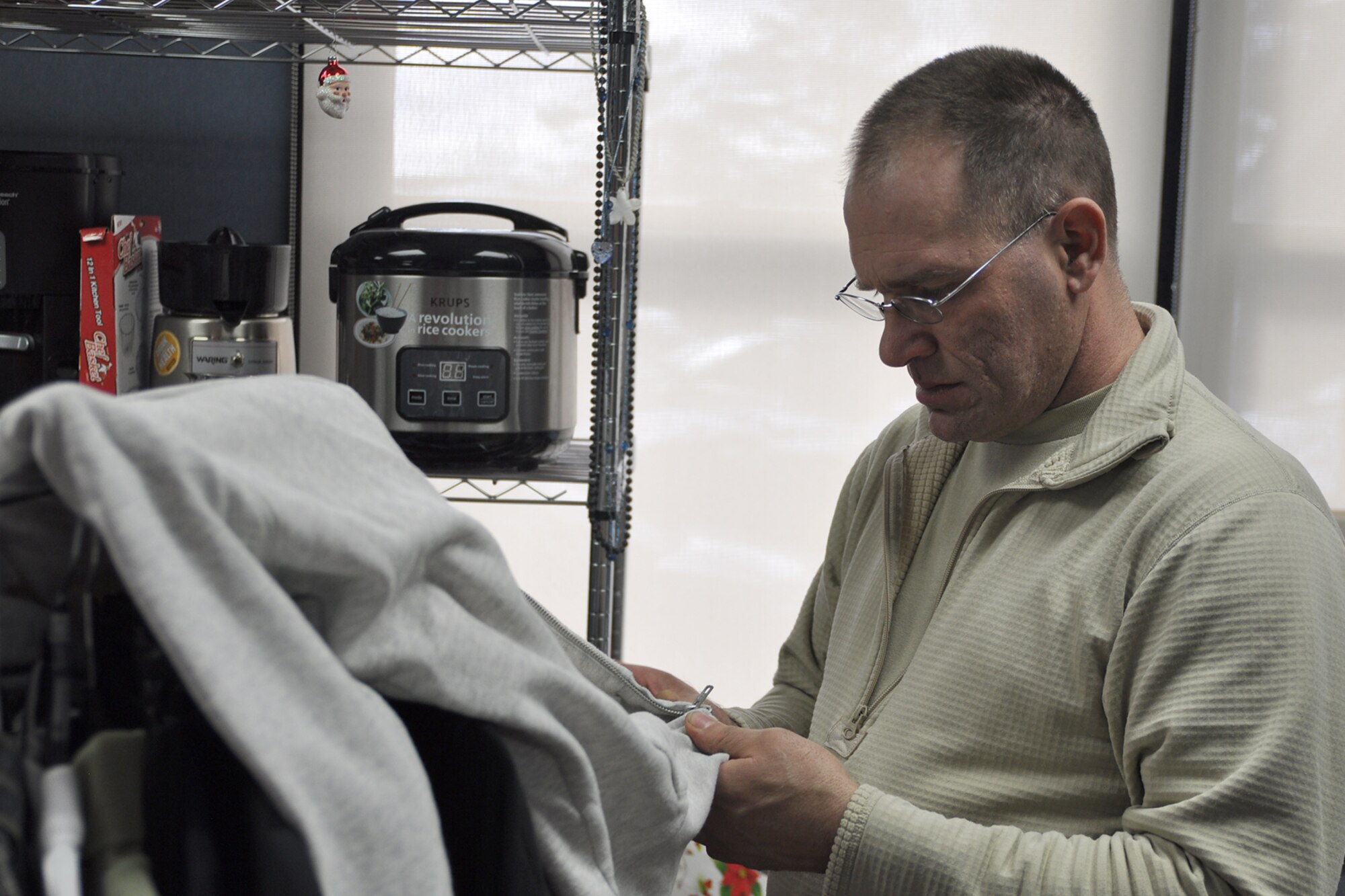 Tech. Sgt. Michael Woodall, Readiness Noncommissioned  Officer (NCO)  for the 910th Airlift Wing Airman and Family Readiness Center (A&FRC) prepares to hang up a clothing item at the Airman’s Attic here, Jan. 7, 2017. The Airman’s Attic, located in Building 112, is open from 11 a.m. to 1 p.m. on Unit Training Assembly (UTA) weekends and Enlisted Airmen from E-1 to E-5 are encouraged to utilize the facility, but it is available to any and all Airmen that are in need. The Airman’s Attic is also accepting donations of gently used or like new goods and those interested in donating may contact Woodall via text message to 330-347-5287. (U.S. Air Force photo/Senior Airman Joshua Kincaid)