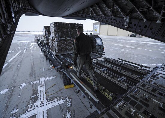 315th Airlift Wing loadmasters coordinate loading of humanitarian cargo onto a Joint Base Charleston C-17 Globemaster III Jan. 13, 2017 at Minneapolis-St. Paul Air Reserve Station, Minnesota.  The 315th AW hauled more than 50,000 pounds in donated meals to Ramstein Air Base, Germany. The cargo will be later delivered to refugees in northern Iraq. (U.S. Air Force photo by Senior Airman Tom Brading)