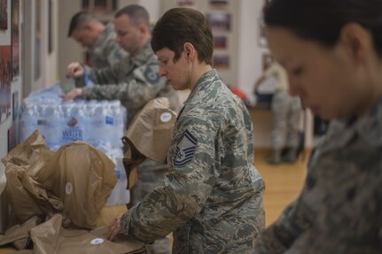 U.S. Air Force Band members assist in meal preparation at Joint Base Anacostia-Bolling, District of Columbia, Jan. 13, 2017. Approximately 300 bags were pre-packed for the band, Air Force Reserve, and Air Force Guard to eat during the inaugural parade rehearsal, Jan. 15. (U.S. Air Force photo by Airman 1st Class Valentina Lopez)