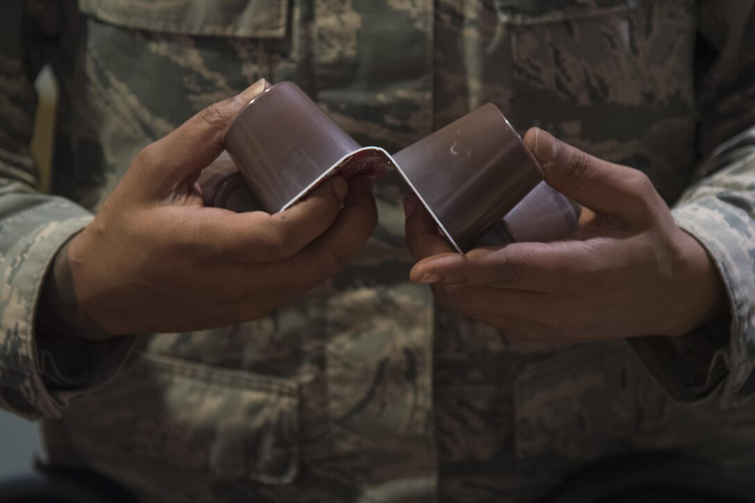 A Joint Base Andrews Airman breaks apart pudding packages at Joint Base Anacostia-Bolling, District of Columbia, Jan. 13, 2017. Pudding, juice boxes and apples were packed as part of meals for the band, Air Force Reserve, and Air Force Guard to eat during the inaugural parade rehearsal, Jan. 15. (U.S. Air Force photo by Airman 1st Class Valentina Lopez)