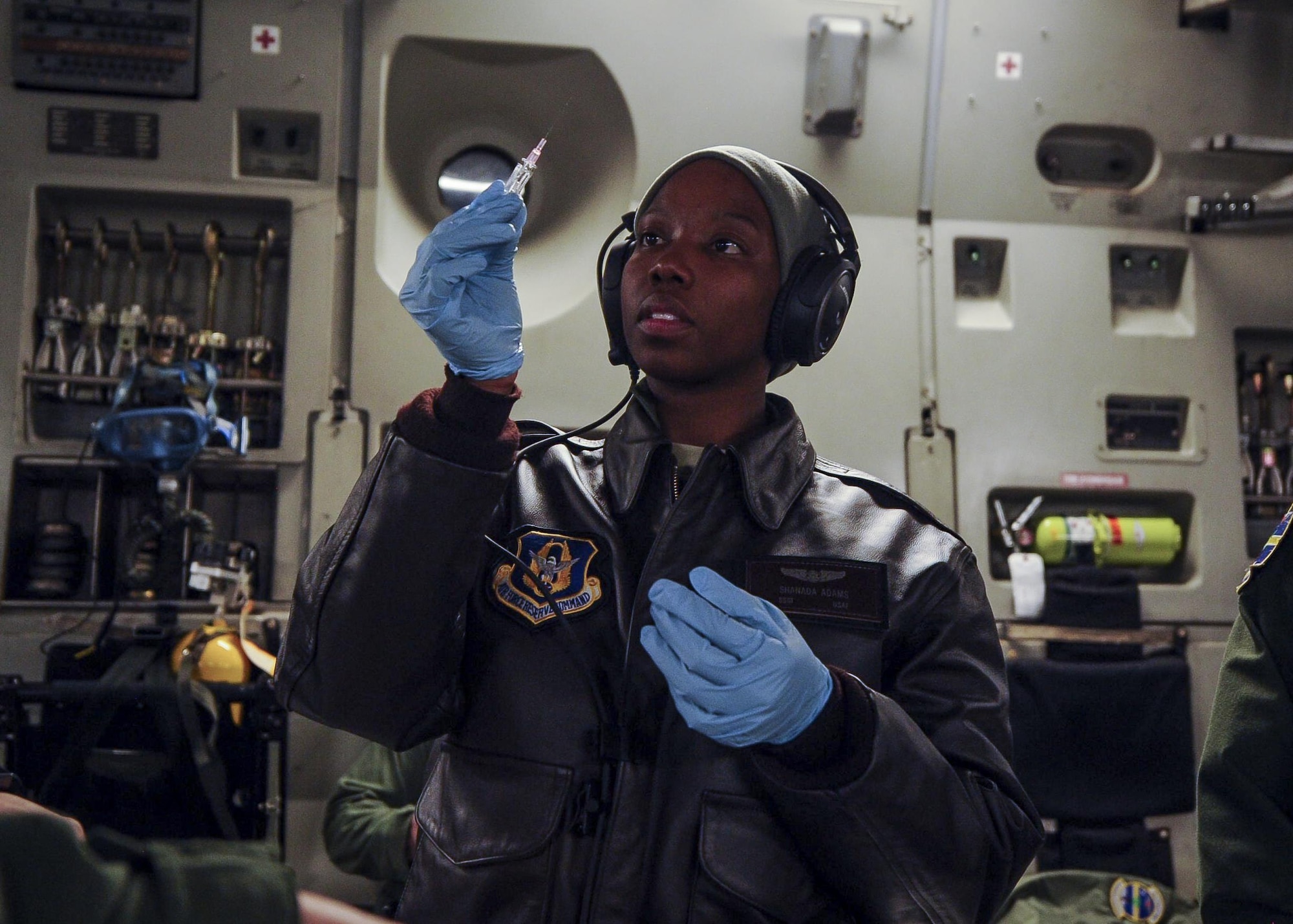 Staff Sgt. Shanada Adams, 315th Aeromedical Evacuation Squadron, tests sterilized needle before administering it onto a replicated human arm during a medical training exercise January 13, 2017, while on board a C-17 Globemaster III bound for Ramstein Air Base, Germany. Airmen from the 315th AES are able to conduct medical training, while in conjunction with real-world operations. (U.S. Air Force photo by Senior Airman Tom Brading)