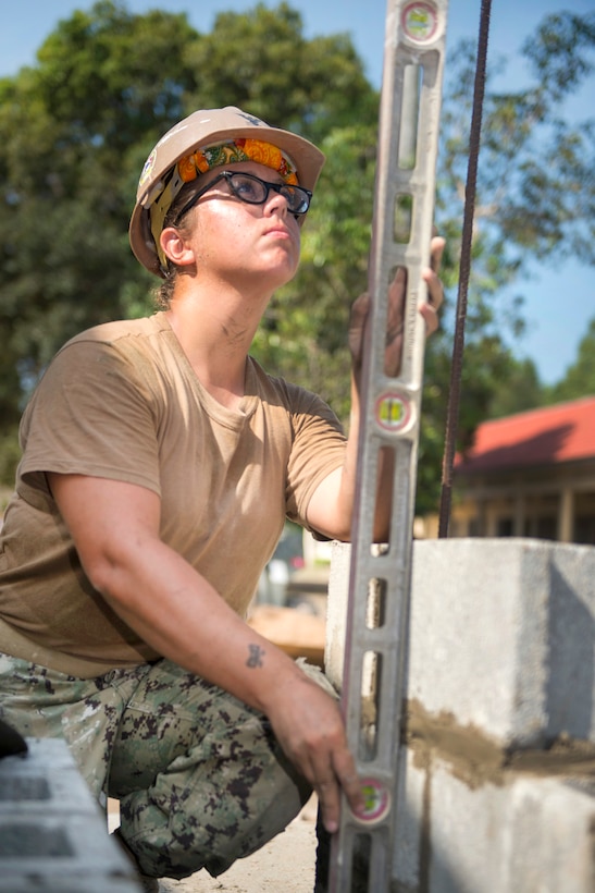Navy Petty Officer 2nd Class Shanna Mckee levels blocks for a five-stall bathroom project at the Sromo Primary School in Svay Rieng province, Cambodia, Jan. 10, 2017. Mckee is a steelworker assigned to Naval Mobile Construction Battalion 5. Navy photo by Petty Officer 1st Class Benjamin A. Lewis