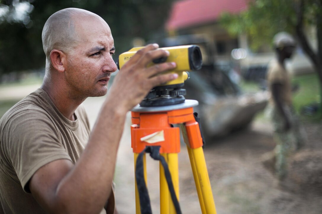 Navy Petty Officer Builder 1st Class Devin Trussell shoots elevations for a five-stall bathroom project being built for the Sromo Primary School in Svay Rieng province, Cambodia, Jan. 11, 2017. Trussell is a builder assigned to Naval Mobile Construction Battalion 5. Navy photo by Petty Officer 1st Class Benjamin A. Lewis