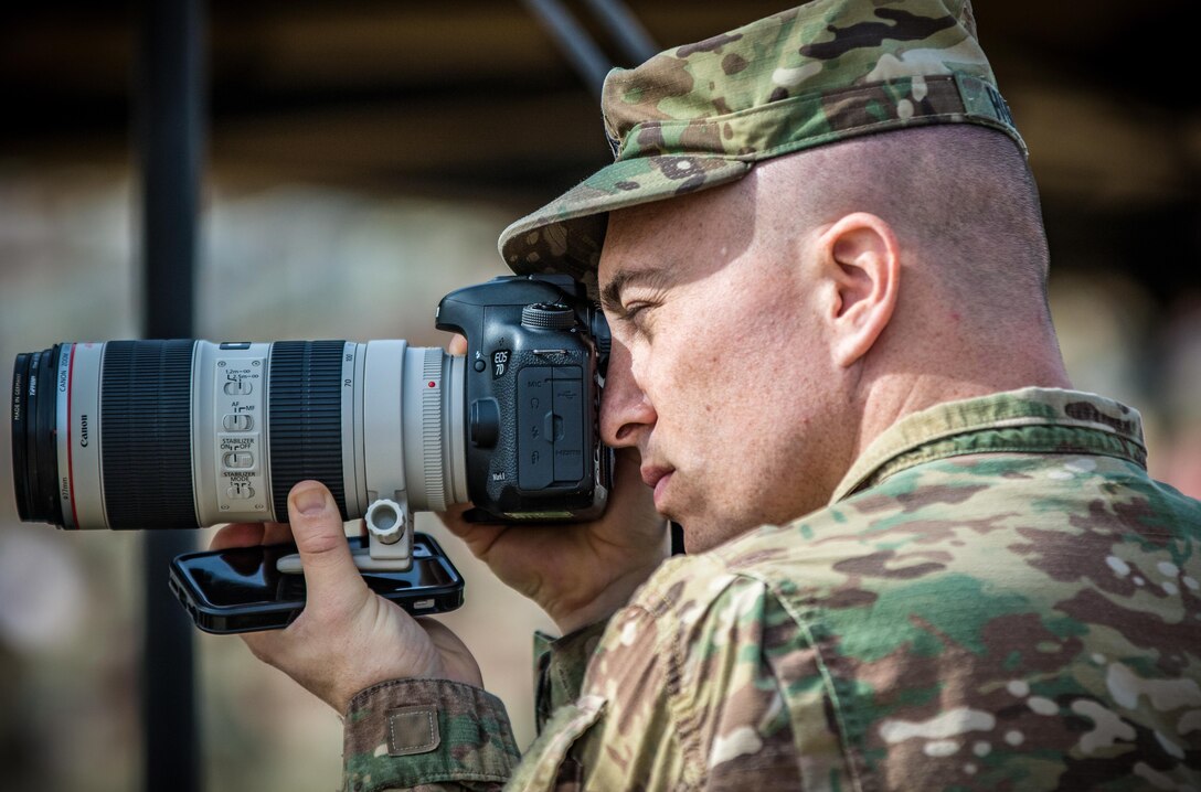 Sgt. Brandon Hubbard, a public affairs noncommissioned officer with the 204th Public Affairs Detachment, 99th Regional Support Command, takes photos during a transfer-of-authority ceremony Dec. 19, 2016 at Camp Arifjan, Kuwait. Hubbard is a U.S. Army Reserve Soldier deployed to Kuwait to provide professional photo and print journalistic support to U.S. Army Central. (U.S. Army photo by Sgt. Angela Lorden)