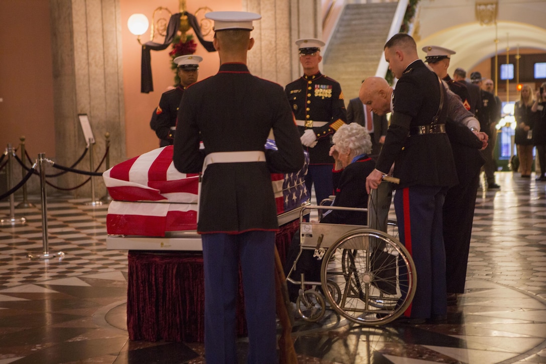 Annie Glenn grieves at the casket of her husband U.S. Sen. John H. Glenn, Jr., at the Ohio Statehouse in Columbus, Ohio, Dec. 16, 2016. Having flown 149 combat missions in World War II and the Korean War, John Glenn became the first man to orbit the earth in 1962. After retiring from the space program, Glenn was elected to the Ohio State Senate in 1974. (U.S. Marine Corps photo by Lance Cpl. Paul Ochoa/Released)