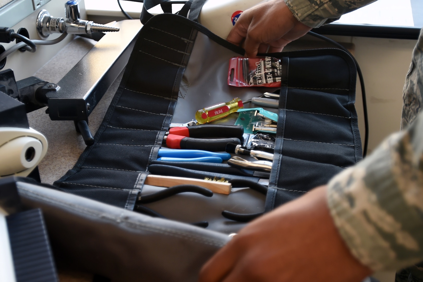 Senior Airman Donnell Johnson, 59th Medical Logistics and Readiness Squadron biomedical equipment technician, sifts through his tool kit during a Nov. 17 service call at the U.S. Air Force Post Graduate Dental School on Joint Base San Antonio-Lackland, Texas. The 59th MLRS BMET section is comprised of scheduled and unscheduled maintenance teams, initial inspectors, contracting services, quality assurance, information technology and technical assessment services. (U.S. Air Force photo/Staff Sgt. Jason Huddleston)