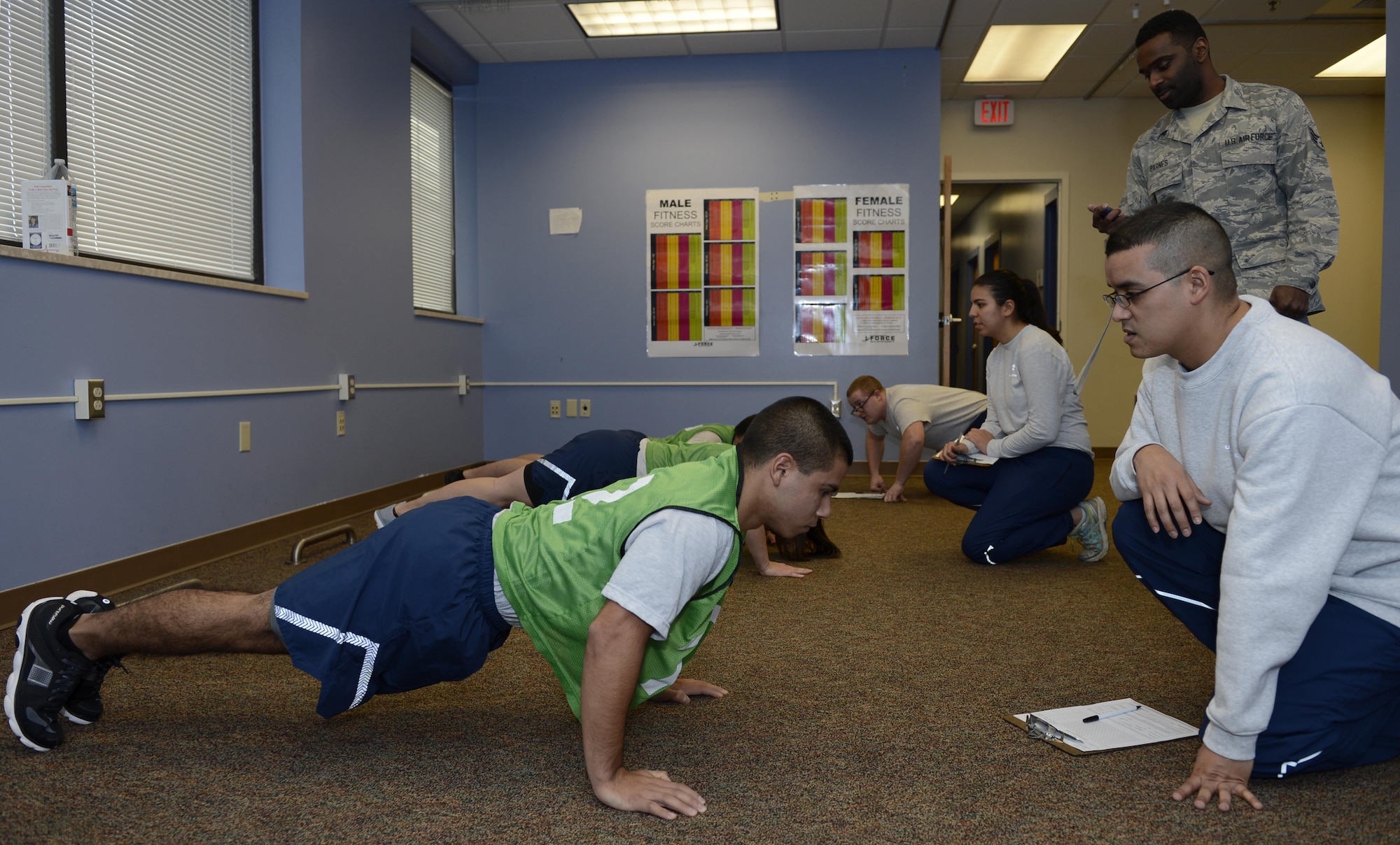 The 633rd Force Support Squadron fitness assessment center fitness specialists and physical training augmentees monitor Airmen performing the push-up component of a PT test at Joint Base Langley-Eustis, Va. Jan. 12, 2017. To ensure test members receive the most accurate test scores, only trained FAC members and augmentees are permitted to count repetitions during PT tests. (U.S. Air Force photo by Airman 1st Class Kaylee Dubois) 