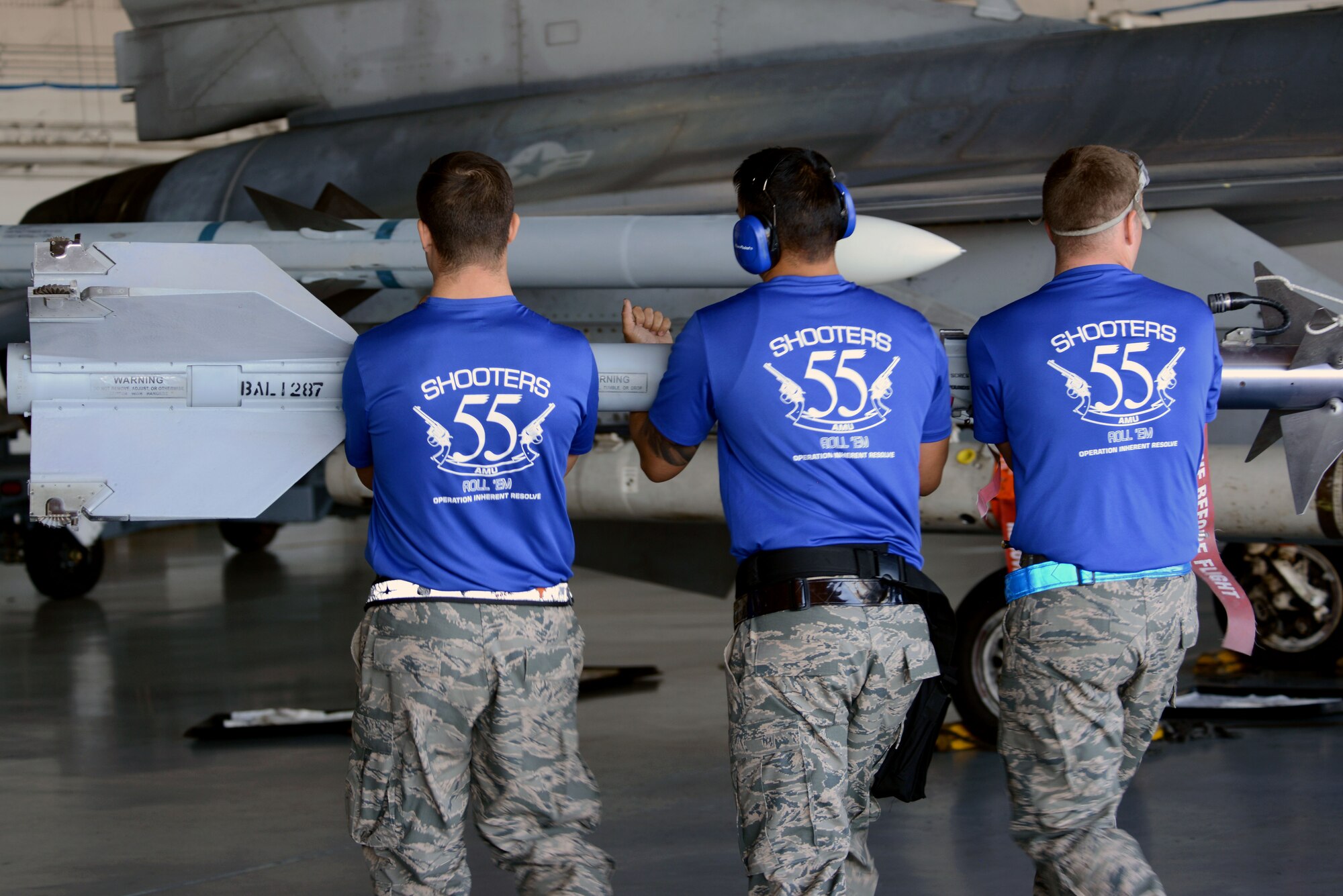 U.S. Air Force Airman 1st Class Dillon Litteral, left, Senior Airman Brandon Atwell, right, 20th Aircraft Maintenance Squadron weapons load crew members, and Staff Sgt. Paolo Santos, center, 20th AMXS weapons load crew chief, work as a team to load a AIM-9M Sidewinder missile onto an F-16CM Fighting Falcon at Shaw Air Force Base, S.C., Jan. 13, 2017. The AIM-9M Sidewinder missile is the only munition that can be loaded by hand due to it being lighter than other F-16 munitions. (U.S. Air Force photo by Airman 1st Class Kathryn R.C. Reaves)