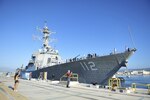 A family member waves goodbye to USS Michael Murphy (DDG 112) on the piers, Jan. 13, 2017. Michael Murphy departed Pearl Harbor, Hawaii for a regularly-scheduled deployment with the Carl Vinson Carrier Strike Group to the Indo-Asia-Pacific Region. 